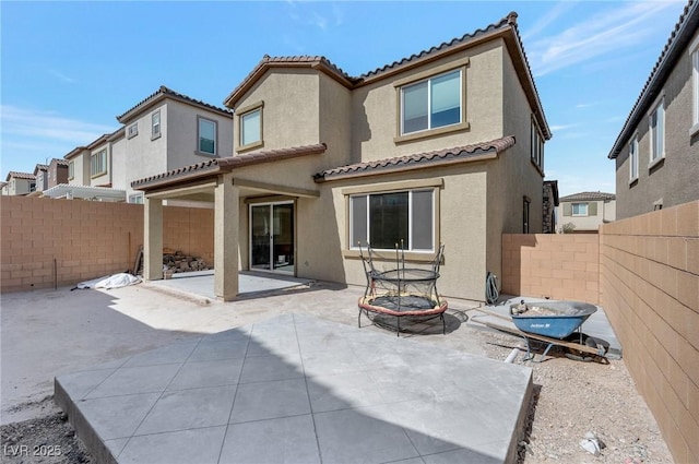 back of house featuring a patio area, a tile roof, a fenced backyard, and stucco siding