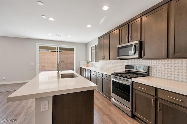 kitchen with plenty of natural light, stainless steel appliances, a sink, and light countertops