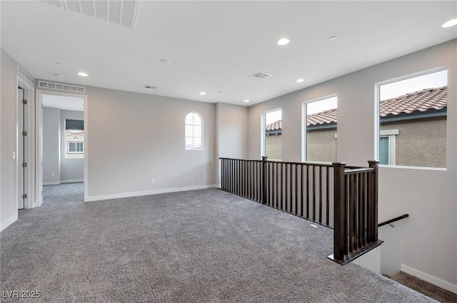 spare room featuring carpet floors, recessed lighting, visible vents, and baseboards