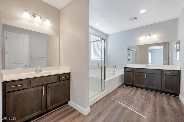 full bathroom featuring a bath, a stall shower, a sink, and visible vents