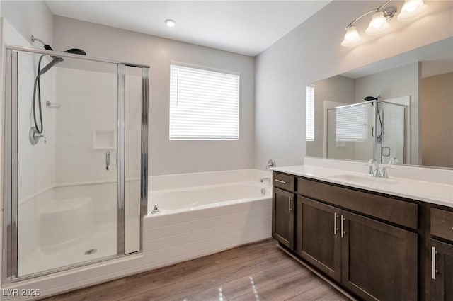 bathroom with vanity, a stall shower, wood finished floors, and a bath