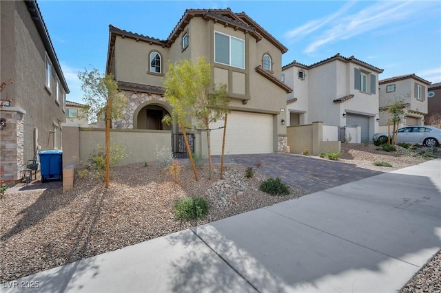 mediterranean / spanish-style house with a garage, fence, decorative driveway, a residential view, and stucco siding