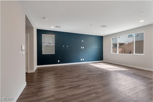 unfurnished room featuring recessed lighting, visible vents, baseboards, and wood finished floors