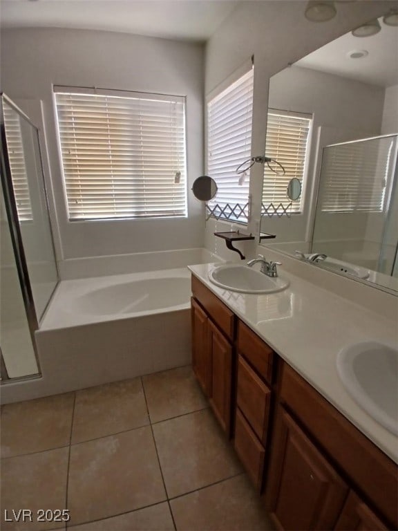 full bath featuring a stall shower, a garden tub, a sink, and tile patterned floors