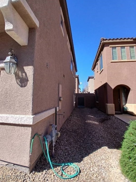 view of home's exterior with fence and stucco siding