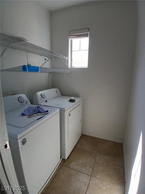 laundry area featuring laundry area, light tile patterned flooring, and washing machine and clothes dryer