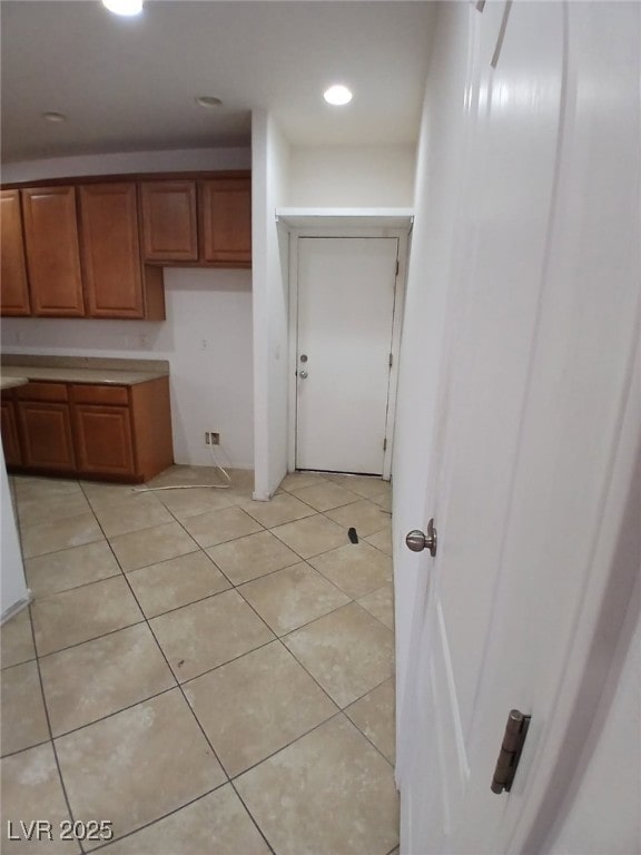 kitchen with light countertops, brown cabinets, and light tile patterned floors