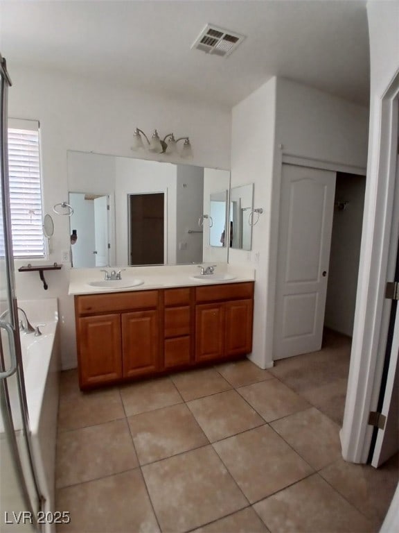 full bathroom featuring double vanity, visible vents, a sink, and tile patterned floors