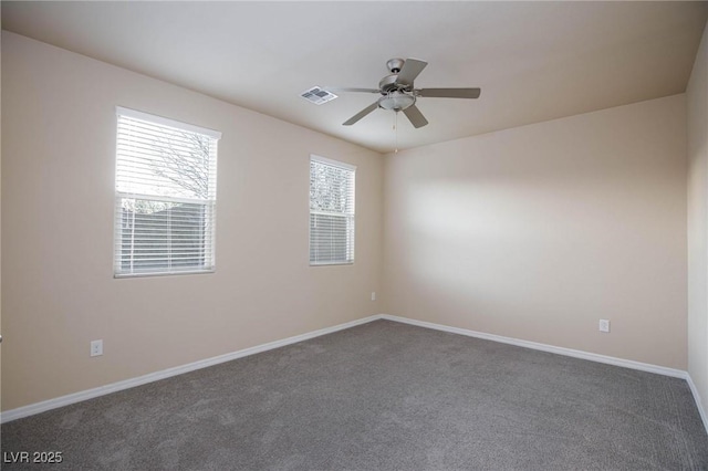 carpeted spare room with ceiling fan, visible vents, and baseboards