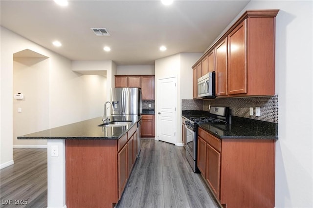 kitchen with tasteful backsplash, visible vents, appliances with stainless steel finishes, dark wood-type flooring, and a sink