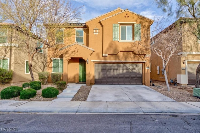 view of front facade with a garage, concrete driveway, a tile roof, and stucco siding