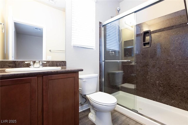 full bath with toilet, visible vents, a stall shower, and vanity