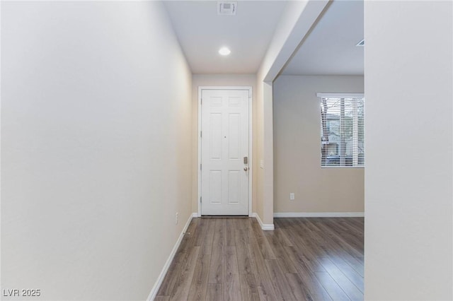 doorway to outside featuring visible vents, baseboards, and wood finished floors