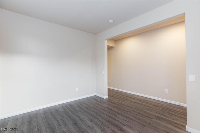 unfurnished room with dark wood-style floors and baseboards