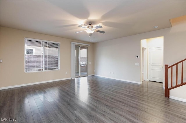 empty room featuring stairway, wood finished floors, and baseboards