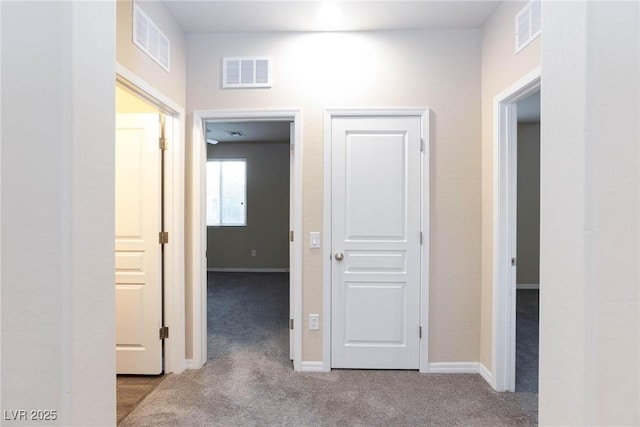 hall featuring carpet, visible vents, and baseboards