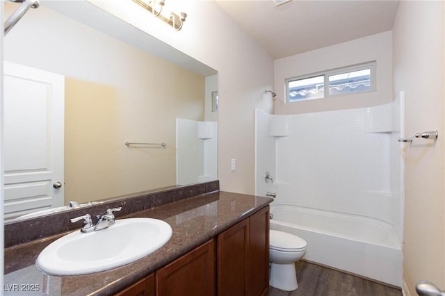 full bath with tub / shower combination, vanity, toilet, and wood finished floors