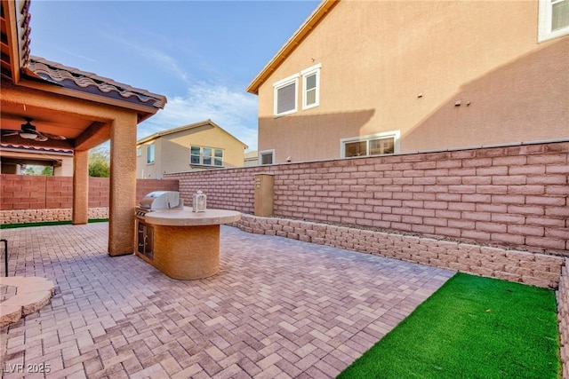 view of patio / terrace with a ceiling fan, a fenced backyard, a grill, and area for grilling