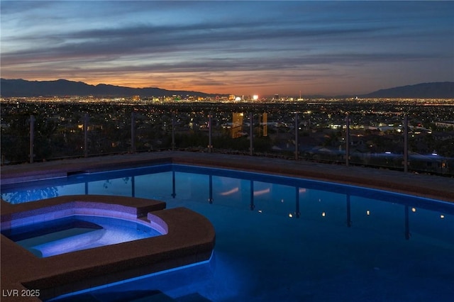 view of swimming pool with a pool with connected hot tub and a mountain view