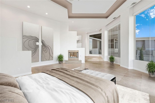 bedroom featuring baseboards, a multi sided fireplace, visible vents, and recessed lighting