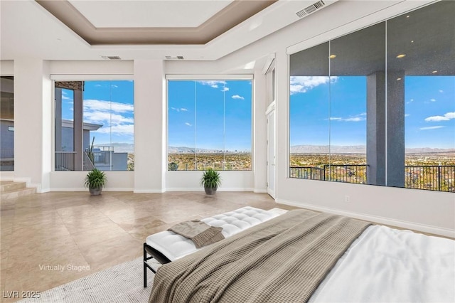 bedroom featuring multiple windows, visible vents, and a tray ceiling