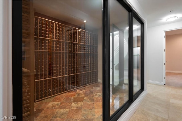 wine room featuring stone finish flooring and baseboards