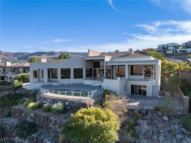 back of property with a mountain view and stucco siding