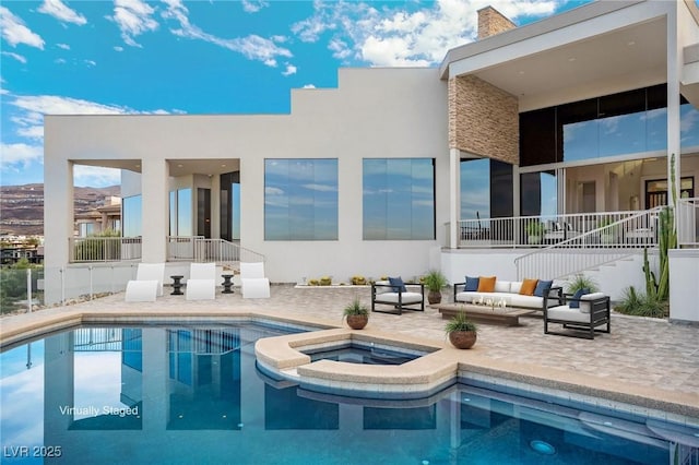 rear view of house featuring a patio, a chimney, a pool with connected hot tub, outdoor lounge area, and stucco siding