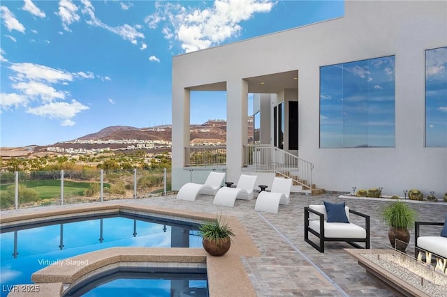 pool featuring an in ground hot tub, a mountain view, and a patio