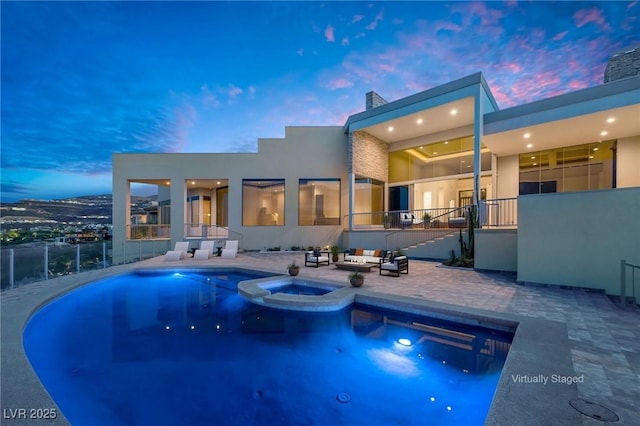 view of pool featuring a pool with connected hot tub, fence, and a patio