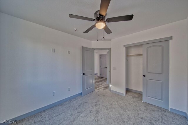 unfurnished bedroom featuring baseboards, ceiling fan, a closet, and light colored carpet