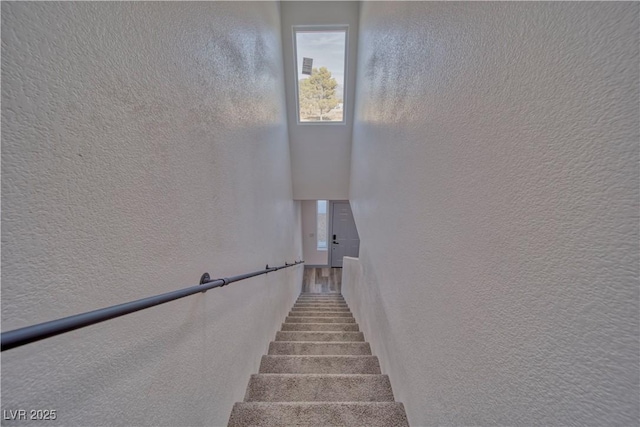 stairway featuring a textured wall