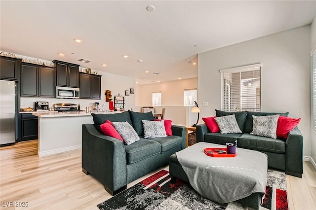 living room with light wood-style flooring, recessed lighting, and a wealth of natural light