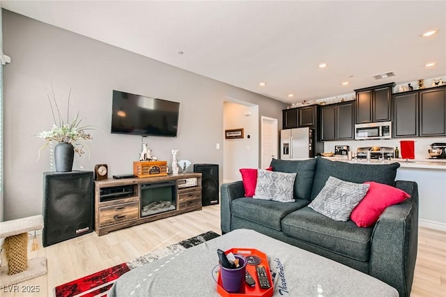 living area featuring recessed lighting, light wood-style floors, visible vents, and baseboards