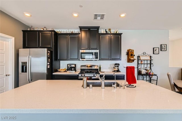 kitchen featuring visible vents, a center island with sink, recessed lighting, appliances with stainless steel finishes, and a sink