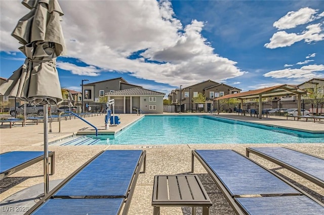 pool featuring a patio area, fence, and a residential view