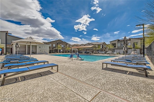 pool featuring a patio area, a residential view, and fence