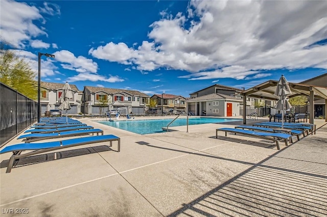 pool featuring a residential view, a patio, and fence