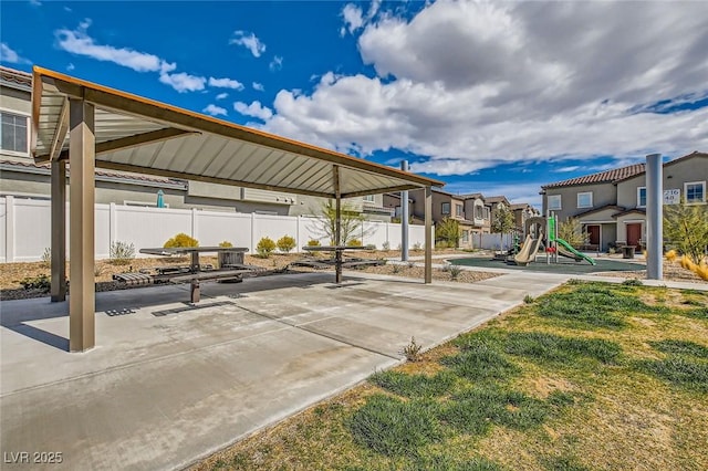 exterior space featuring a residential view, playground community, and fence