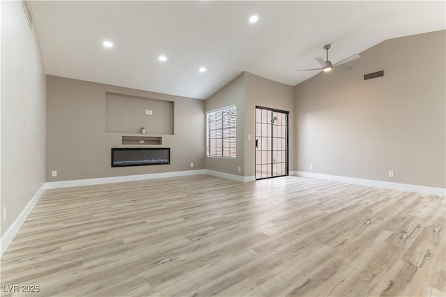 unfurnished living room featuring lofted ceiling, ceiling fan, visible vents, light wood finished floors, and a glass covered fireplace