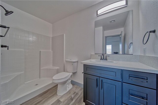 384 E Erin St Unit 3, Pahrump, NV 89048 - full bathroom with visible vents, toilet, vanity, wood finished floors, and tiled shower