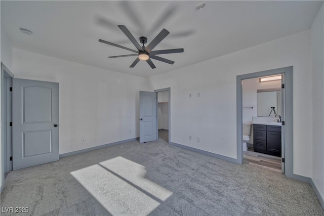 unfurnished bedroom featuring connected bathroom, light colored carpet, a ceiling fan, baseboards, and a spacious closet