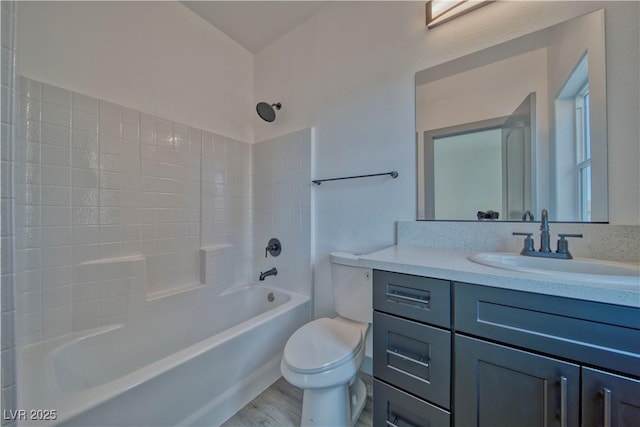 bathroom with toilet, shower / tub combination, wood finished floors, and vanity