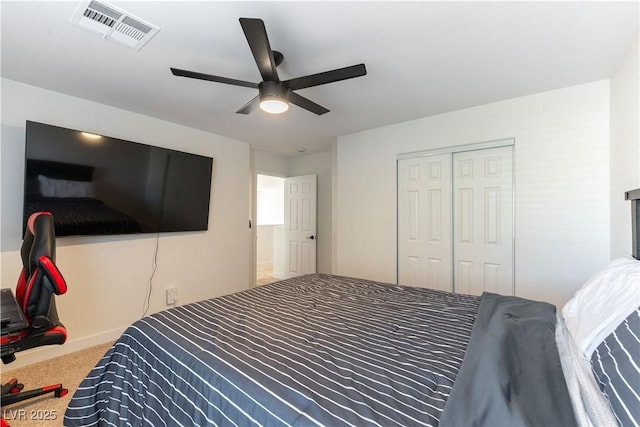 bedroom featuring carpet floors, ceiling fan, visible vents, and a closet