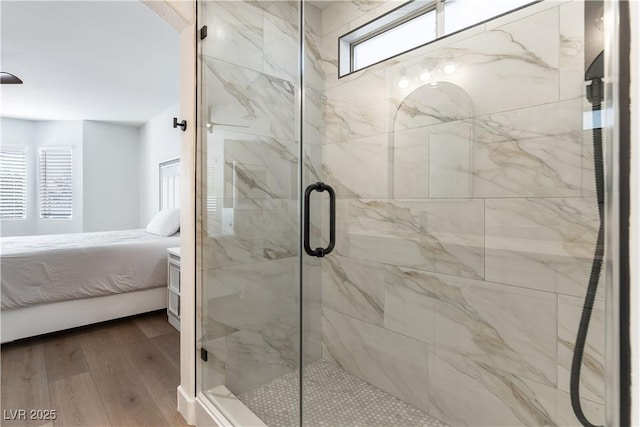 ensuite bathroom with connected bathroom, a marble finish shower, and wood finished floors