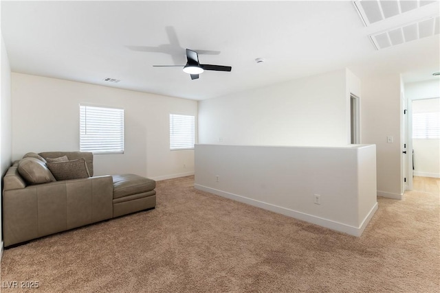 living area featuring light carpet, plenty of natural light, and visible vents