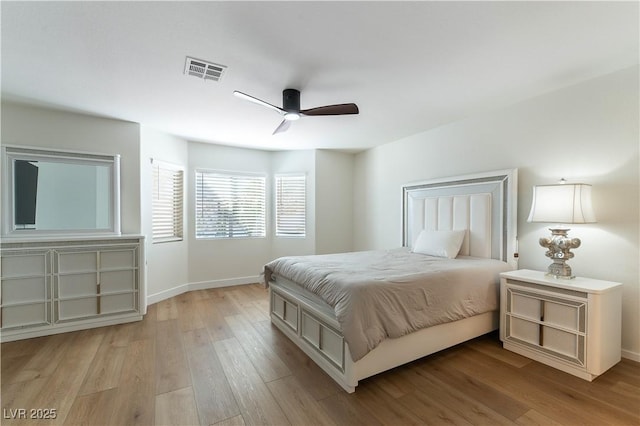 bedroom with light wood-style flooring, a ceiling fan, visible vents, and baseboards