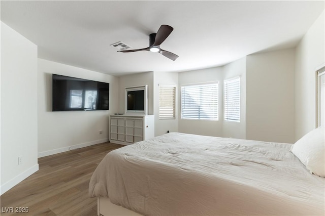 bedroom with visible vents, baseboards, ceiling fan, and wood finished floors