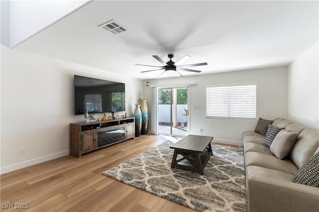 living area featuring a ceiling fan, visible vents, light wood-style flooring, and baseboards