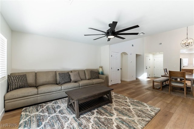 living room featuring a healthy amount of sunlight, light wood-style flooring, visible vents, and lofted ceiling